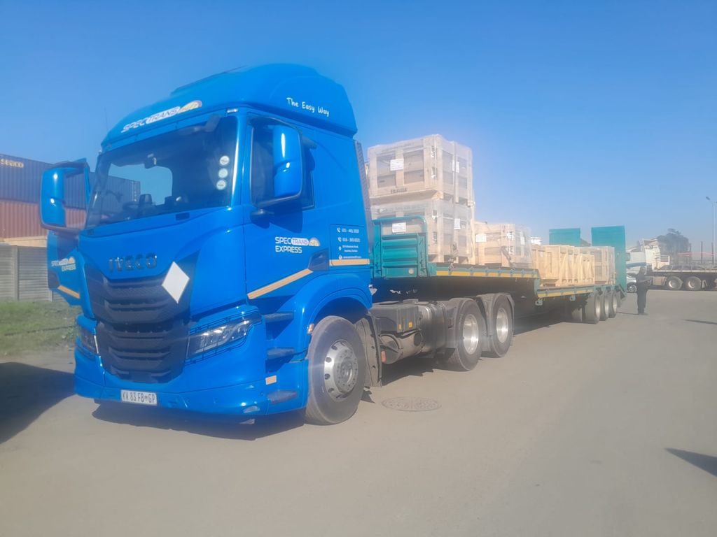 Spectrans truck with a flatbed trailer loaded with palletised crates